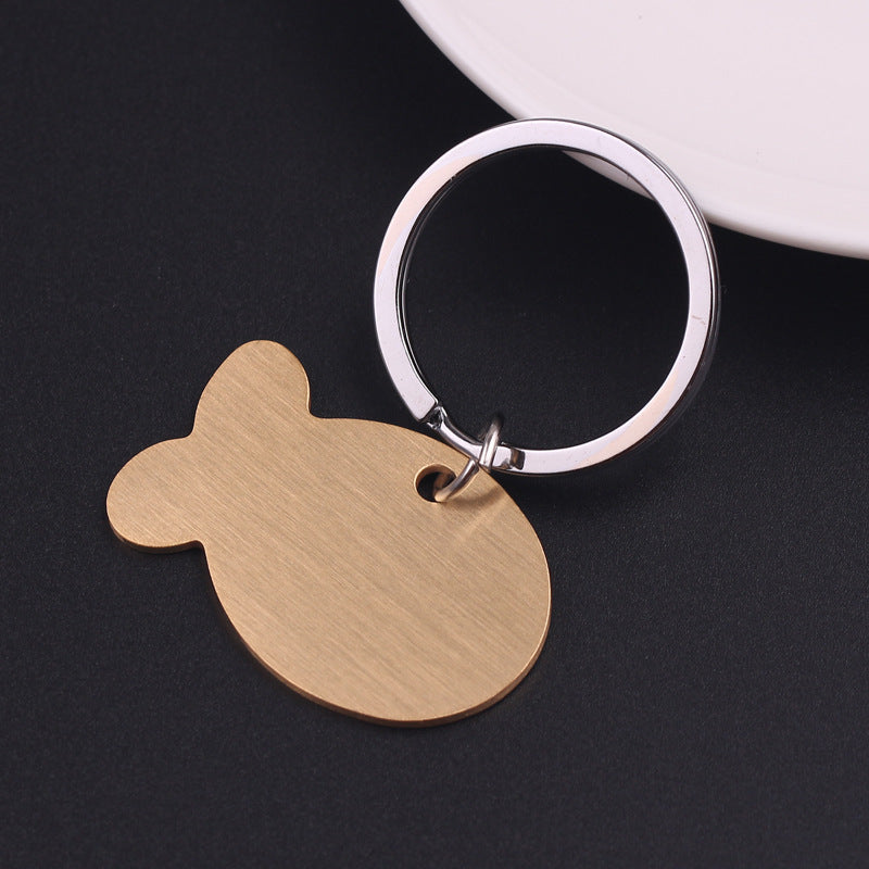 Gold stainless steel pet ID tag with keyring on dark background
