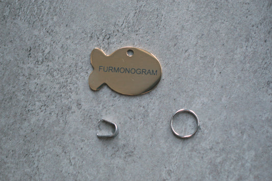 Real photo: gold fish-shaped ID tag with FURMONOGRAM engraving